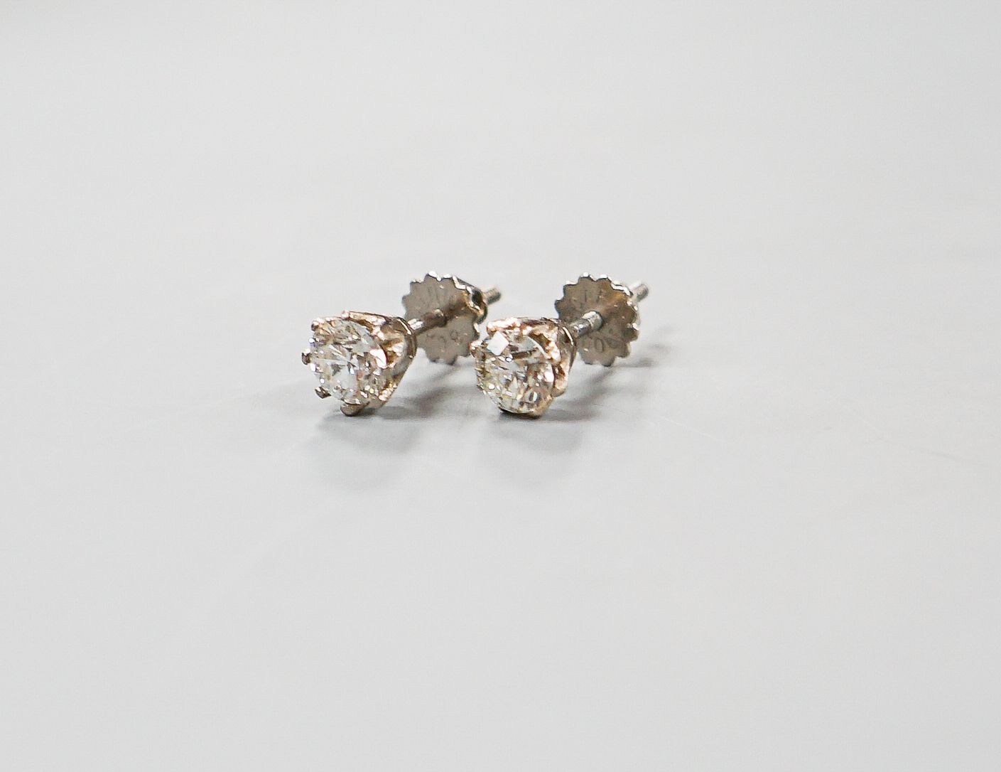 A pair of 18ct white metal and solitaire diamond ear studs, gross weight 2.4 grams